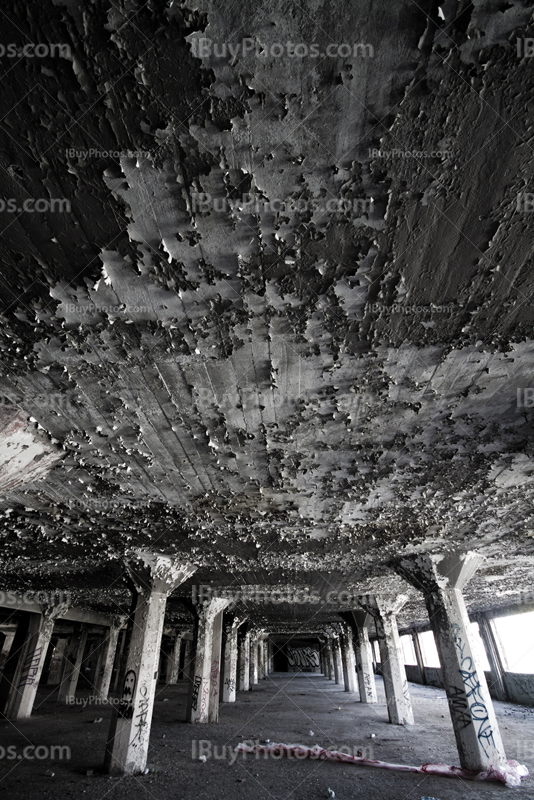 Parking lot perspective with peeling ceiling and pillars in black and white photo