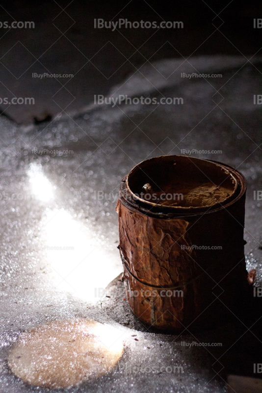 Pain pot with rust on ice in sunlight