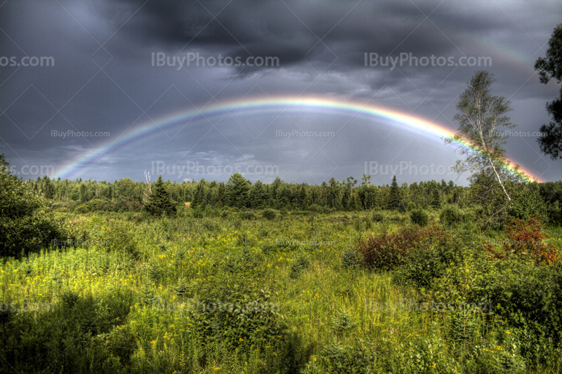 Arc-en-ciel complet en photo HDR pendant orage avec nuages gris