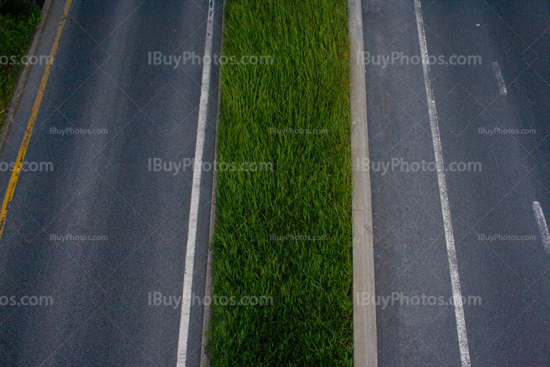 Road lines on the highway separated by grass median strip