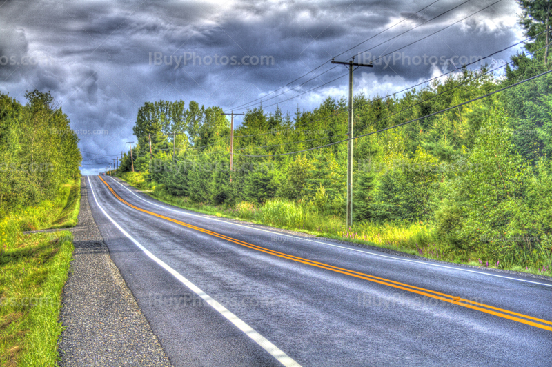 Asphalt road HDR in countryside with trees and cloudy sky