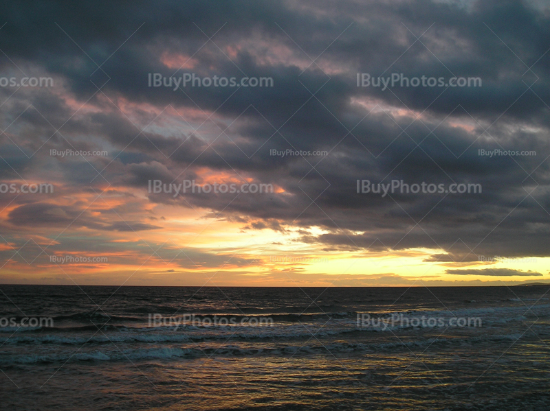 Coucher de Soleil en Méditerranée, mer avec des vagues et ciel orageux