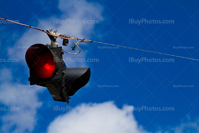 Red road sign on wire with cloudy sky