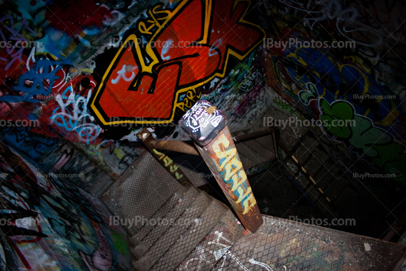 Dirty spiral staircase in dilapidated factory with graffiti