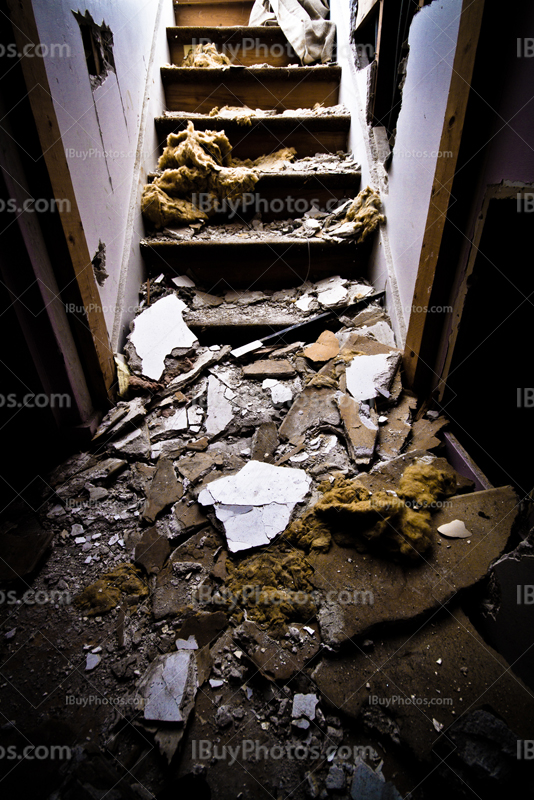 Stairs with fragments in abandoned house, light from top