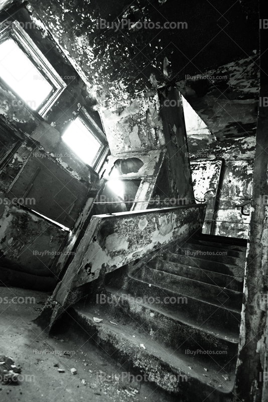 Old creepy stairs in abandoned asylum with peeling walls