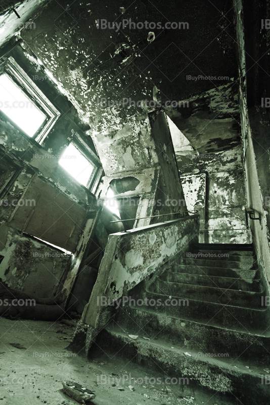 Stairs art lighting in abandoned asylum, with light through windows