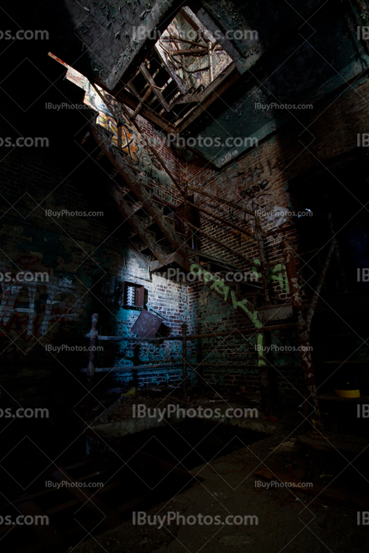 Rusty stairs and graffiti in derelict factory building with light painting