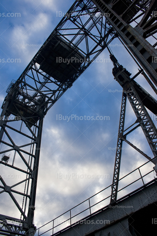 Metal arch structure with steel beams with cloudy sky