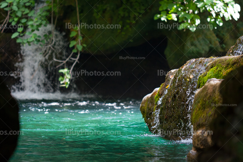 Turquoise river with waterfall, moss on rocks