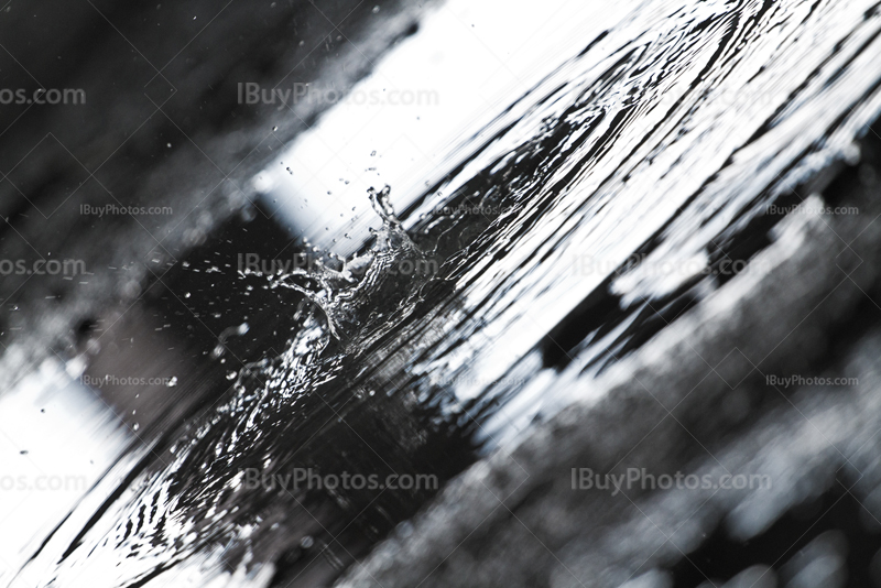 Water splash in puddle on concrete ground