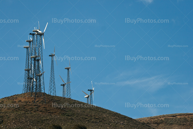 Windmills on hills on blue sky
