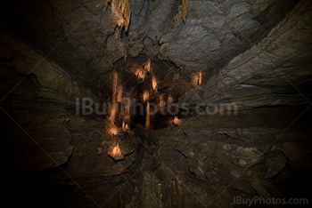 Cave interior perspective with light on stalactites and stalagmites