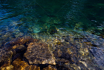 Eau transparente du lac Boom, Alberta, avec rochers