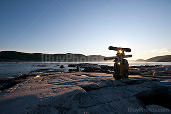 Inuksuk in Tadousac bay, Quebec, at sunset with St Lawrence River