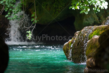 Turquoise river with waterfall, moss on rocks