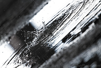 Water splash in puddle on concrete ground