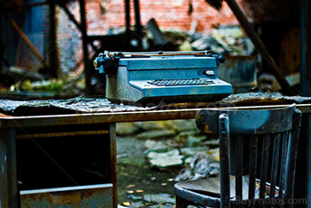 Typewriter on desk with chair in abandoned place