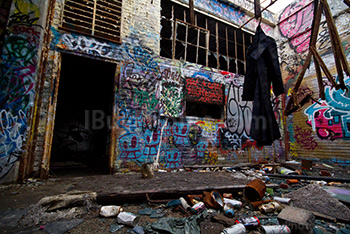 Vêtement sale dans usine abandonnée, mur de graffiti