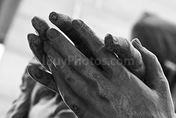 Mains jointes sur une statue en photo noir et blanc