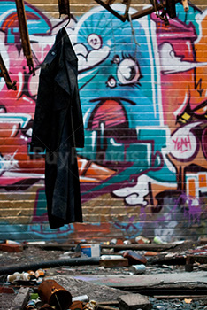 Coat hung in dirty room in abandoned place with spray paintings