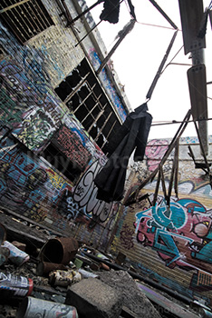 Low-angle picture of coat hanging in dirty place with graffiti