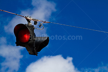 Red road sign on wire with cloudy sky