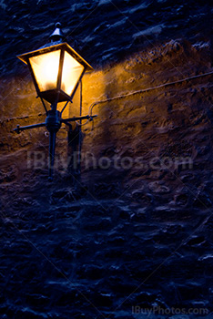 Vieux lampadaire sur un mur de pierre dans la rue