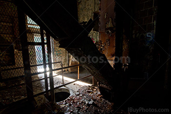 Abandoned factory interior with light from doorway and metal structures