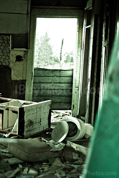 Abandoned house room with toilet and furniture, light coming from door