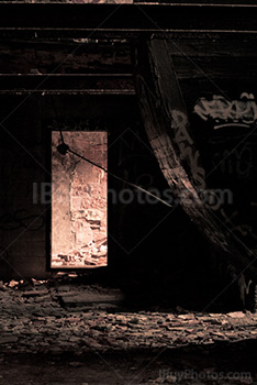 Lumière dans encadrement de porte dans salle avec débris sur le sol