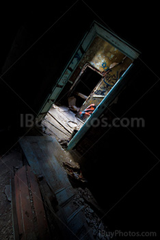 Inclined doorway with light and wood door on floor