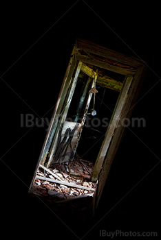 Lumière dans encadrement de porte dans salle sombre de maison abandonnée