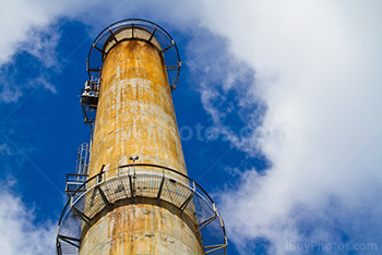 Cheminée d'usine avec escaliers métallique, ciel et nuages