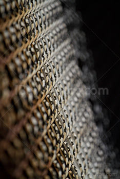 Inclined rusty metal fence, chain link perspective