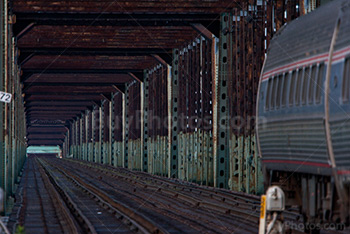 Train and wagons in steel railway bridge, vanishing point