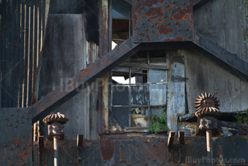 Broken windows and steel beams on rusty metal structure