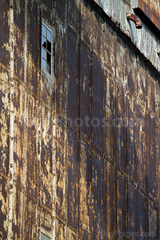 Broken windows on old factory wall with rusty plates